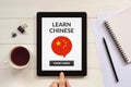 Learn Chinese concept on tablet screen with office objects Royalty Free Stock Photo