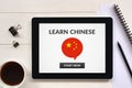 Learn Chinese concept on tablet screen with office objects Royalty Free Stock Photo