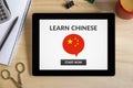 Learn Chinese concept on tablet screen with office objects Royalty Free Stock Photo