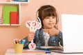 Learn English concept with kids, girl using her laptop. Kid using laptop watching online e-learning video Royalty Free Stock Photo