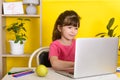 Learn English concept with kids, girl using her laptop. Kid using laptop watching online e-learning video Royalty Free Stock Photo