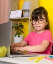 Learn English concept with kids, girl using her laptop. Kid using laptop watching online e-learning video Royalty Free Stock Photo