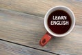 Learn English Text written on coffee cup. Office desk table top view