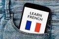 Learn French concept on smartphone screen in jeans pocket Royalty Free Stock Photo