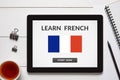 Learn French concept on tablet screen with office objects Royalty Free Stock Photo