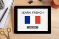 Learn French concept on tablet screen with office objects Royalty Free Stock Photo