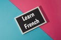 Learn French - text on chalkboard on blue and pink