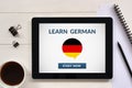 Learn german concept on tablet screen with office objects Royalty Free Stock Photo