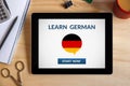 Learn german concept on tablet screen with office objects Royalty Free Stock Photo