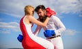 Learn how to defend yourself. Man and woman boxing gloves fight blue sky background. She knows how to defend herself