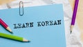 Learn Korean text written on a paper with pencils in office