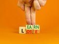 Learn or lose symbol. Concept words Learn and Lose on wooden cubes. Businessman hand. Beautiful orange table orange background. Royalty Free Stock Photo