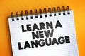 Learn A New Language text quote on notepad, concept background Royalty Free Stock Photo