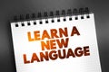 Learn A New Language text quote on notepad, concept background Royalty Free Stock Photo