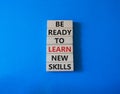 Learn new skills symbol. Concept words Be ready to Learn new skills on wooden blocks. Beautiful blue background. Business and Royalty Free Stock Photo