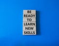 Learn new skills symbol. Concept words Be ready to Learn new skills on wooden blocks. Beautiful blue background. Business and Royalty Free Stock Photo