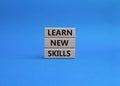 Learn new skills symbol. Concept words Learn new skills on wooden blocks. Beautiful blue background. Business and Learn new Royalty Free Stock Photo