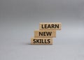 Learn new skills symbol. Concept words Learn new skills on wooden blocks. Beautiful grey background. Business and Learn new