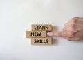 Learn new skills symbol. Concept words Learn new skills on wooden blocks. Beautiful white background. Businessman hand. Busine