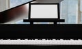 Learn piano online by yourself. Use a tablet or computer to learn piano tutorials online. The black grand piano has a tablet