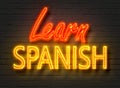 Learn Spanish, neon sign on brick wall