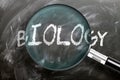 Learn, study and inspect biology - pictured as a magnifying glass enlarging word biology, symbolizes researching, exploring and