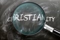 Learn, study and inspect christianity - pictured as a magnifying glass enlarging word christianity, symbolizes researching,