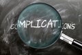 Learn, study and inspect complications - pictured as a magnifying glass enlarging word complications, symbolizes researching, Royalty Free Stock Photo