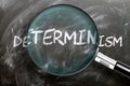 Learn, study and inspect determinism - pictured as a magnifying glass enlarging word determinism, symbolizes researching,