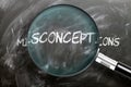 Learn, study and inspect misconceptions - pictured as a magnifying glass enlarging word misconceptions, symbolizes researching,