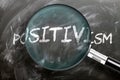 Learn, study and inspect positivism - pictured as a magnifying glass enlarging word positivism, symbolizes researching, exploring Royalty Free Stock Photo