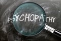 Learn, study and inspect psychopathy - pictured as a magnifying glass enlarging word psychopathy, symbolizes researching,