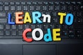 Learn to code advice from colorful letters on notebook keyboard