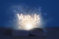Light coming from open book with words vue js. Education concept. Learn programming language