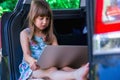 Learn ÃÂ°lways and everywhere concept. Young beautiful girl sitting in the car and using laptop Royalty Free Stock Photo