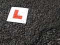 Learner drivers plate against black tarmac Royalty Free Stock Photo