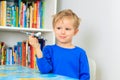 Learning ang travel - little boy playing with toy airplane flying over world map Royalty Free Stock Photo