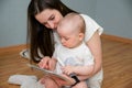 Learning a child with cards. A woman and a small child study images on cards. Mom teaches her baby sitting on the floor