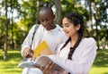 Learning concept. Multiracial student guy and lady preparing for classes, studying with books in university campus Royalty Free Stock Photo