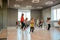 Learning dance figures with teacher. Group of little boys and girls dancing while having choreography class in the dance