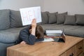 Learning difficulties. Sad tired frustrated boy sitting at the table with many books and holding paper with word Help. Education Royalty Free Stock Photo