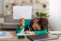 Tired school girl sleeping at table holding paper Royalty Free Stock Photo