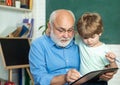 Learning and education concept - generation people concept. Portrait of grandfather and grandson on blackboard in Royalty Free Stock Photo