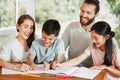 Learning, education and homework with a family writing, drawing and studying together on a table at home. Parents and Royalty Free Stock Photo