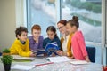 Children reading a book during their English class