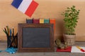 Learning french language concept - blank blackboard, flag of the France, books, pencils, compass Royalty Free Stock Photo