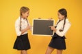 Learning fun at lesson. Cute small schoolchildren reciting lesson at blackboard on yellow background. Little schoolgirls Royalty Free Stock Photo