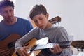 Learning, guitar and child with teacher for music, lesson and development of skill with instrument. Playing, practice Royalty Free Stock Photo