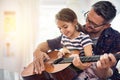 Learning, guitar and girl, man with smile for music or bonding or love or play at house. Happiness, teaching and kid Royalty Free Stock Photo