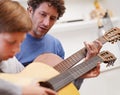 Learning, guitar and teacher in music with child in lesson and development of skill on instrument. Playing, practice and Royalty Free Stock Photo